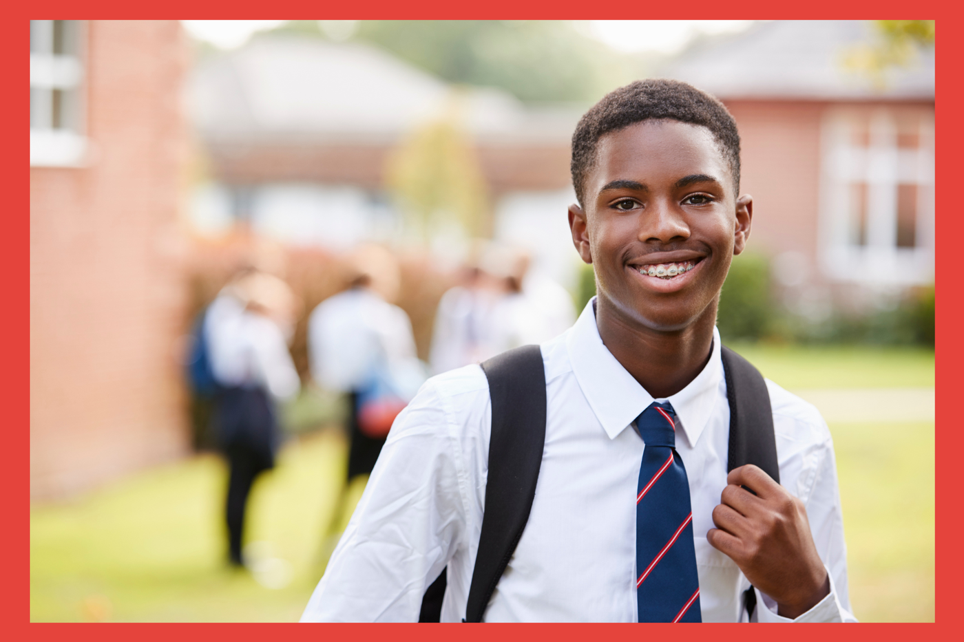 Teen boy. White shirt and tie with backpack. In front of school. 